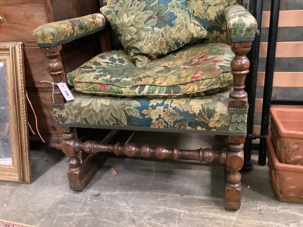 A Jacobean style carved walnut reclining armchair, with tapestry upholstery, width 68cm depth 60cm height 122cm